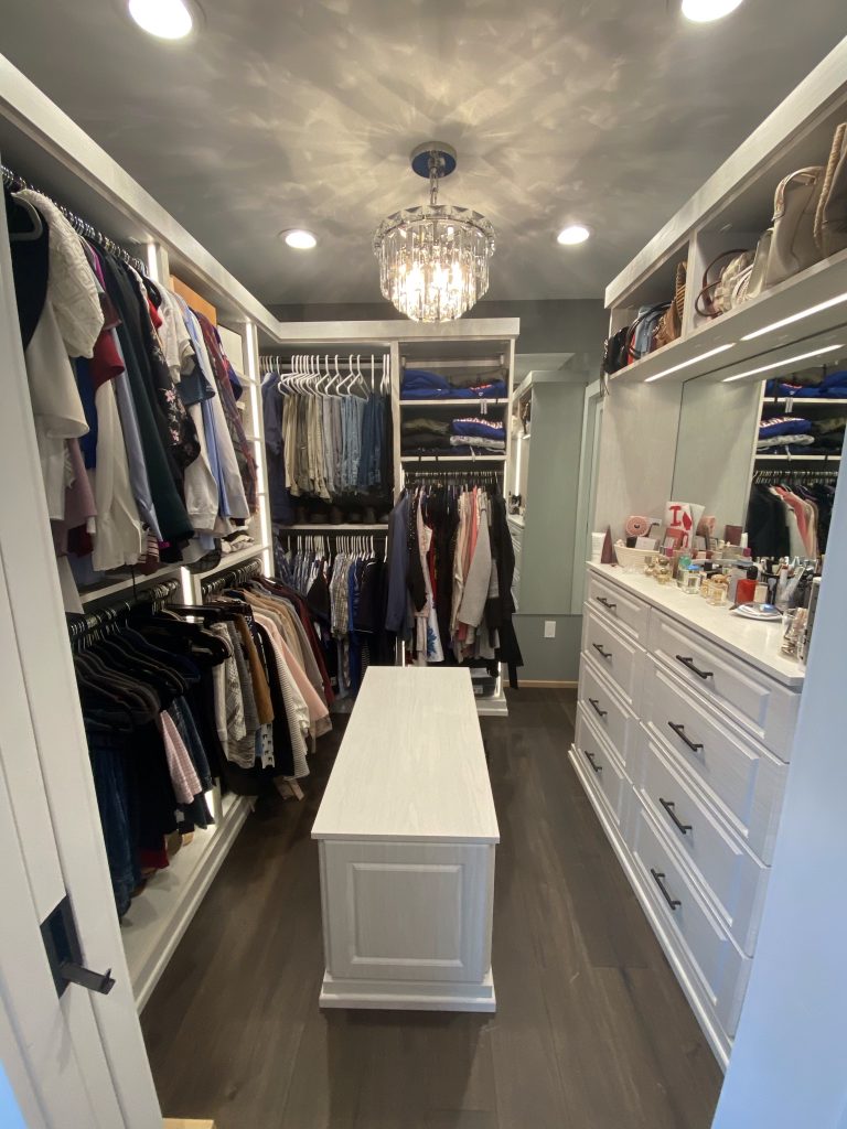 Spare bedroom transformed into a budget-friendly walk-in closet with an island.