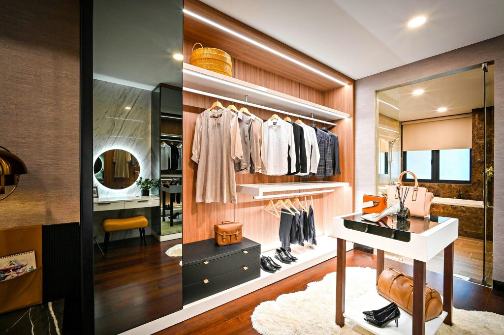 Well-lit commercial closet with seating area and modern drawer fronts.